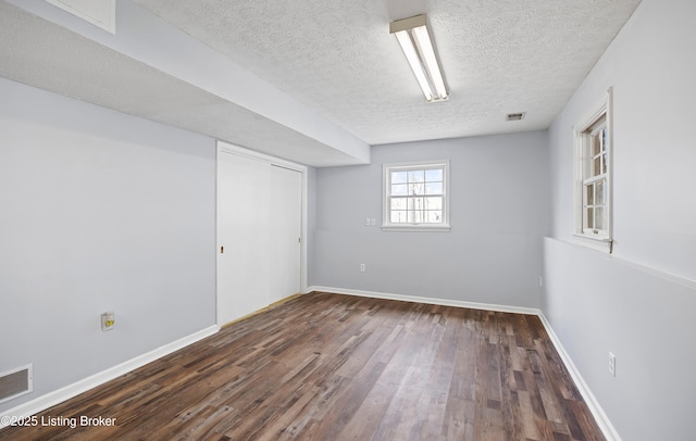 basement with dark wood-type flooring and a textured ceiling