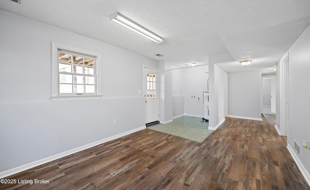 spare room featuring dark hardwood / wood-style floors and a textured ceiling