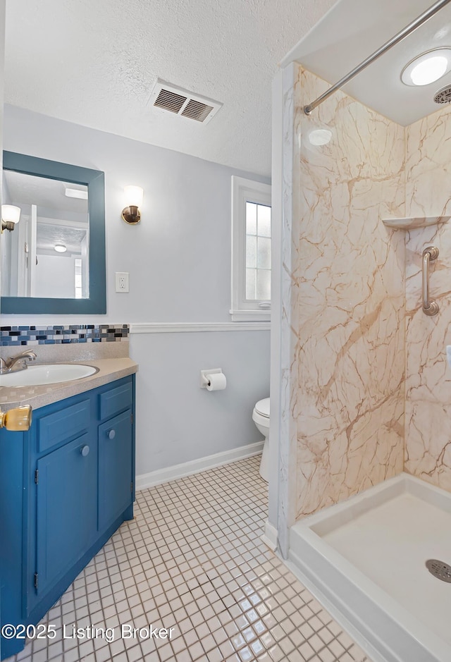 bathroom featuring tiled shower, toilet, a textured ceiling, vanity, and decorative backsplash