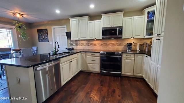 kitchen with stainless steel appliances, kitchen peninsula, sink, and white cabinets