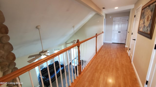 hallway with hardwood / wood-style flooring and vaulted ceiling