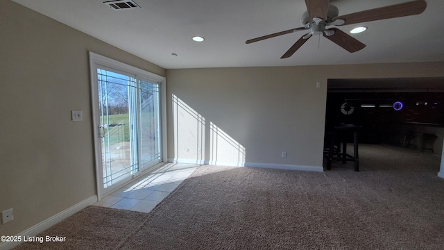 spare room with a healthy amount of sunlight, light carpet, and ceiling fan