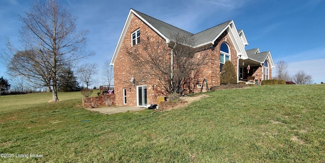 view of side of home featuring a yard and a patio