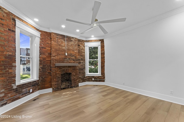 unfurnished living room with crown molding, a wealth of natural light, and a fireplace