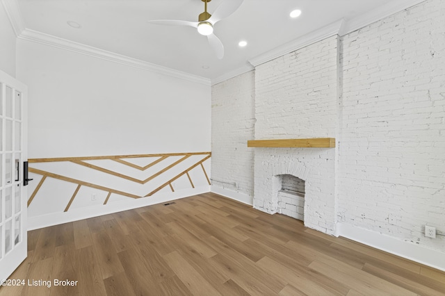 unfurnished living room with ceiling fan, ornamental molding, a fireplace, and hardwood / wood-style floors