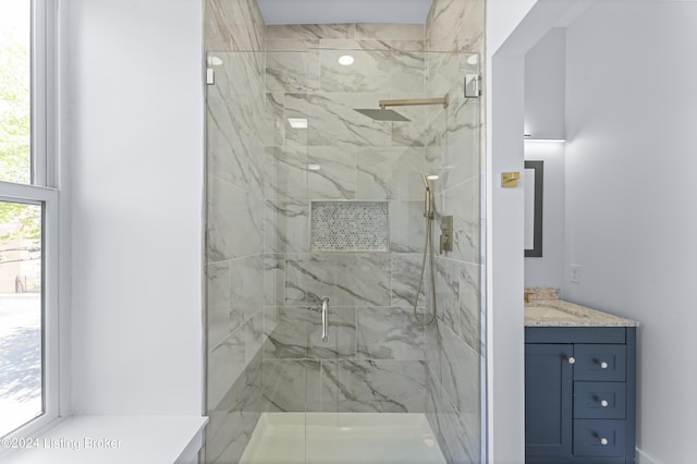 bathroom with plenty of natural light, a shower with door, and vanity