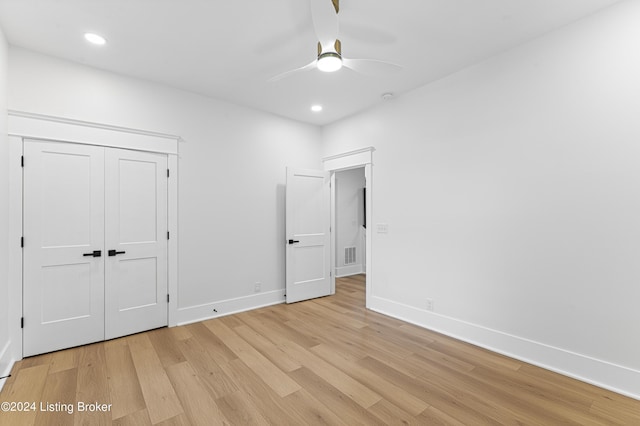 unfurnished bedroom featuring light hardwood / wood-style flooring, a closet, and ceiling fan