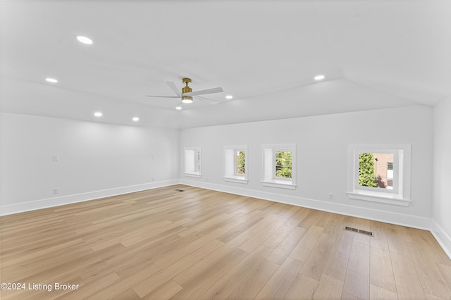 unfurnished room with ceiling fan, vaulted ceiling, and light wood-type flooring