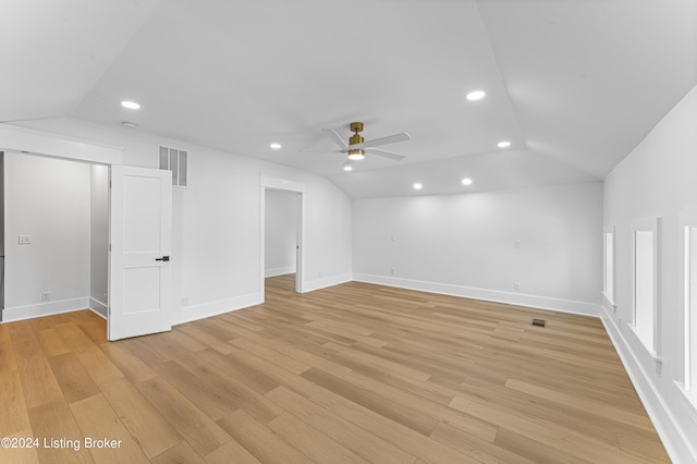 spare room with ceiling fan, lofted ceiling, and light wood-type flooring