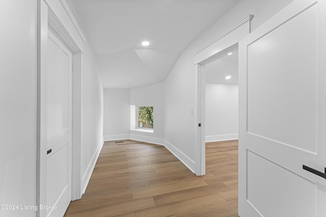 hall featuring lofted ceiling and wood-type flooring