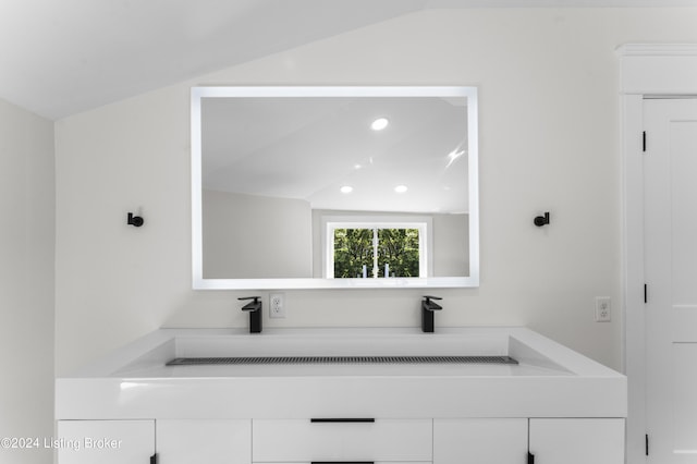 bathroom with lofted ceiling and sink