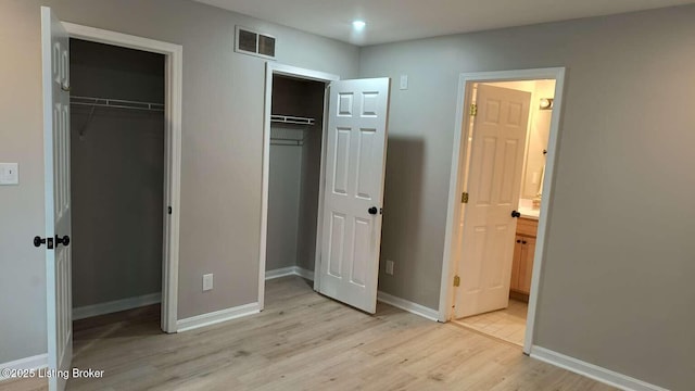 unfurnished bedroom with light wood-type flooring and ensuite bath