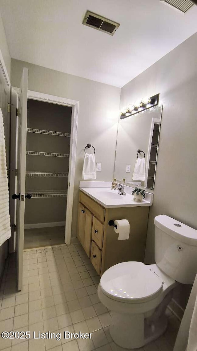 bathroom featuring tile patterned flooring, vanity, and toilet