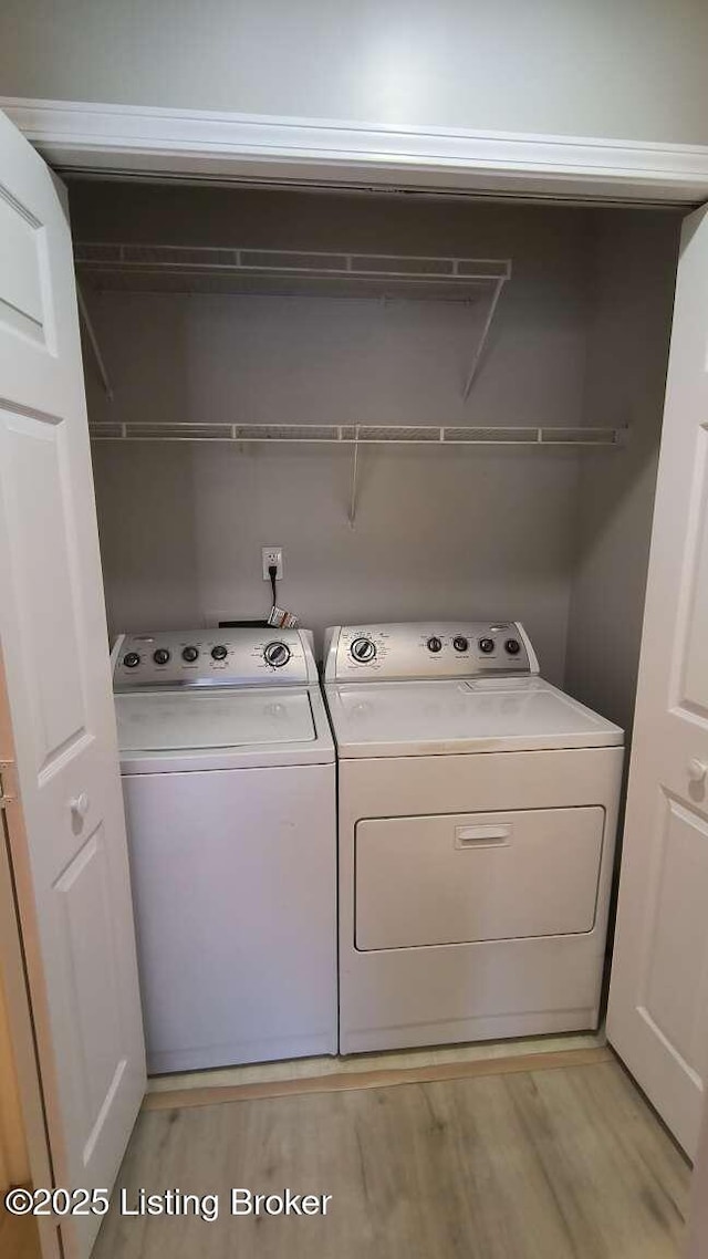 laundry room featuring light hardwood / wood-style flooring and washing machine and clothes dryer