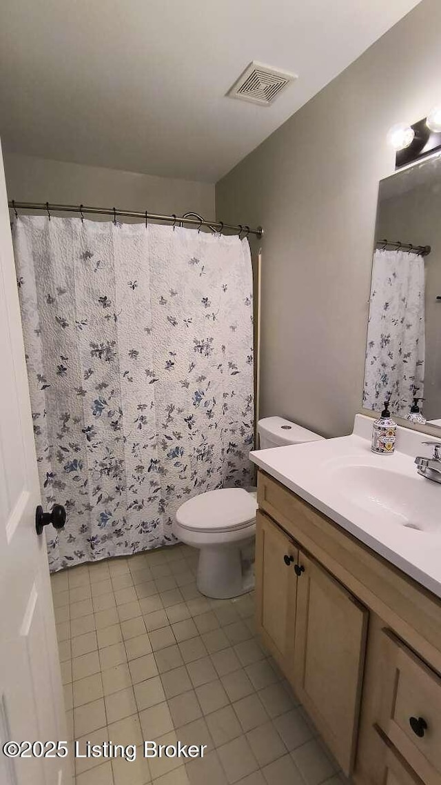 bathroom featuring vanity, tile patterned floors, and toilet