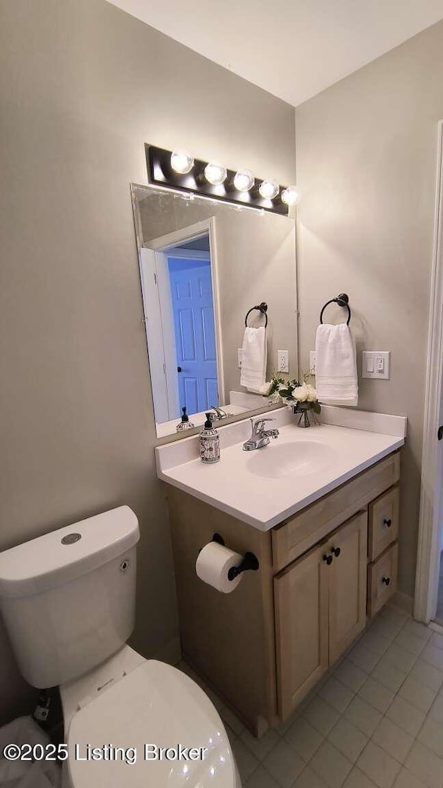 bathroom with tile patterned flooring, vanity, and toilet