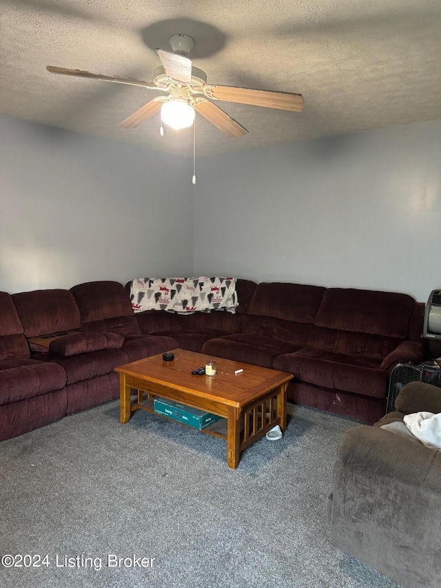 carpeted living room with ceiling fan and a textured ceiling