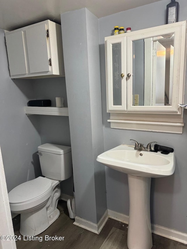 bathroom with hardwood / wood-style floors, sink, and toilet