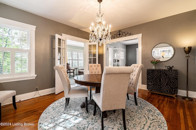 dining space with dark hardwood / wood-style flooring and a chandelier