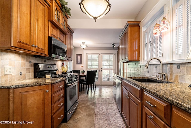 kitchen featuring sink, dark tile patterned floors, backsplash, stainless steel appliances, and french doors