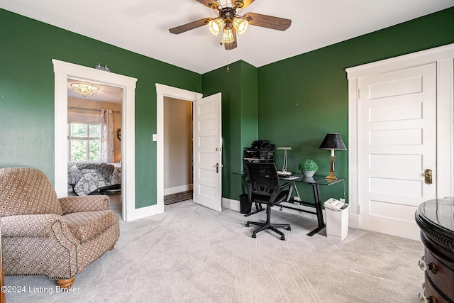 carpeted office space featuring ceiling fan