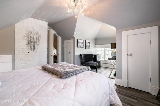 bedroom with lofted ceiling, hardwood / wood-style flooring, and an inviting chandelier