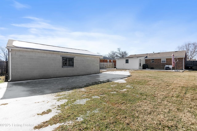 back of house featuring a lawn and a patio area