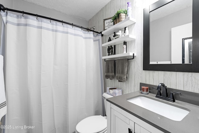 bathroom with vanity, toilet, and a textured ceiling