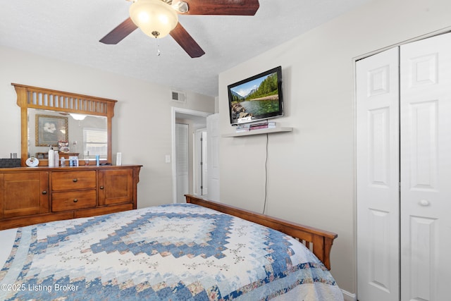 bedroom with a textured ceiling, ceiling fan, and a closet