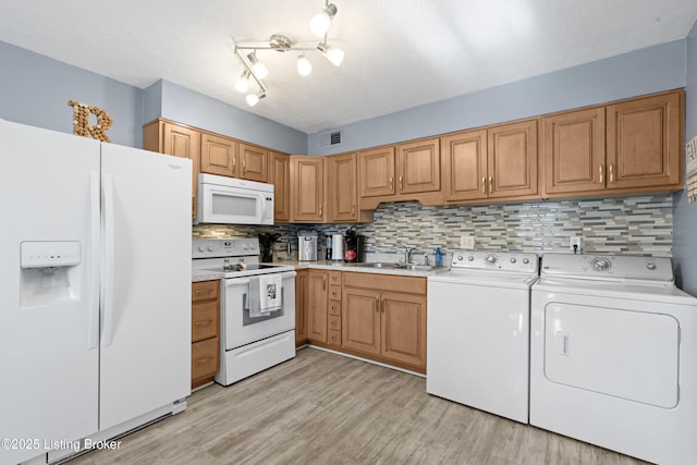 kitchen featuring sink, backsplash, white appliances, independent washer and dryer, and a textured ceiling