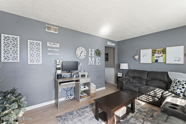 living room with wood-type flooring and a textured ceiling