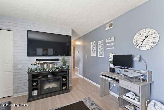 living room featuring a textured ceiling and light hardwood / wood-style flooring