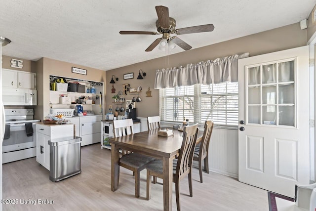 dining space featuring ceiling fan, washer and clothes dryer, a textured ceiling, and light hardwood / wood-style flooring