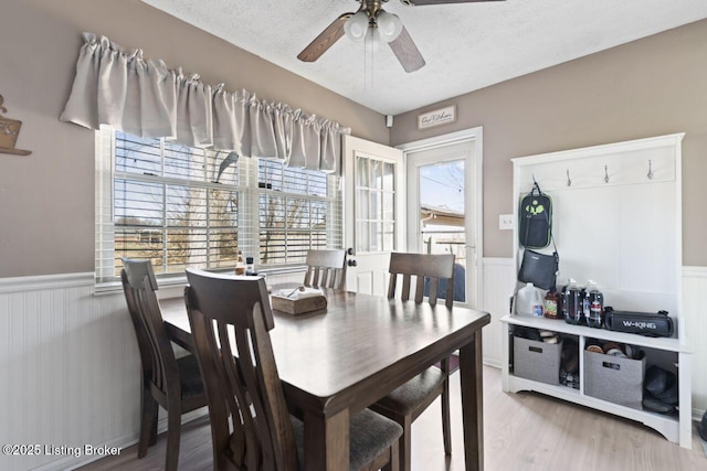 dining area with ceiling fan, a textured ceiling, and light wood-type flooring