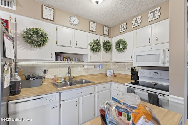 kitchen featuring white cabinetry, white appliances, sink, and tasteful backsplash