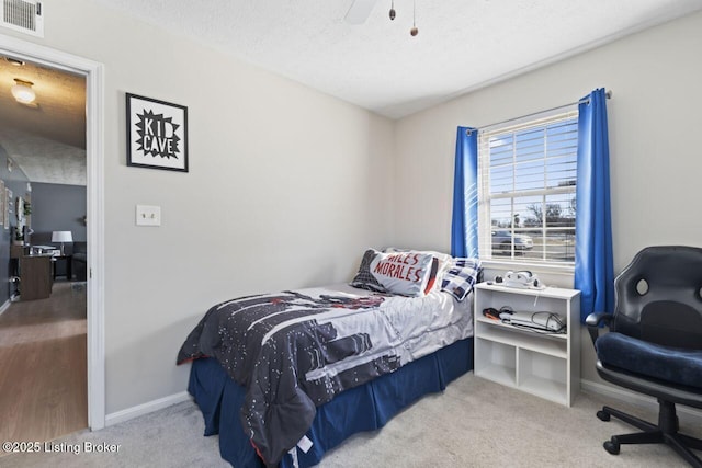 bedroom featuring light carpet and a textured ceiling