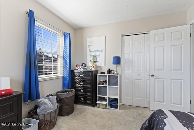 carpeted bedroom with a closet and a textured ceiling