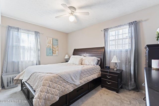 carpeted bedroom with multiple windows, ceiling fan, and a textured ceiling