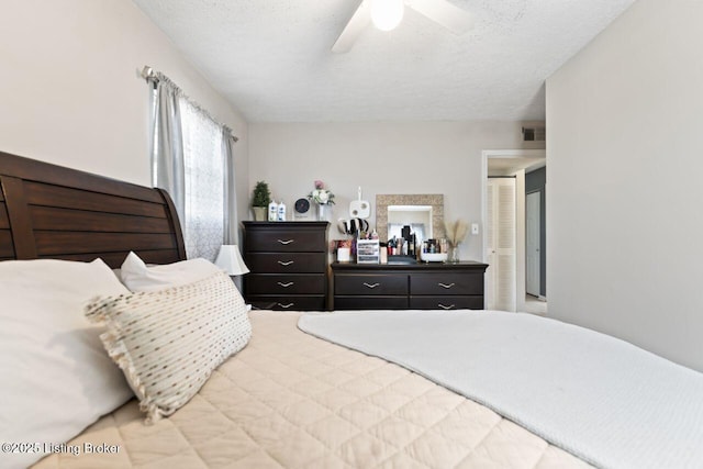 bedroom featuring ceiling fan and a textured ceiling