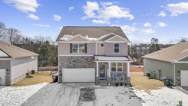 front of property with a garage, central AC, and covered porch