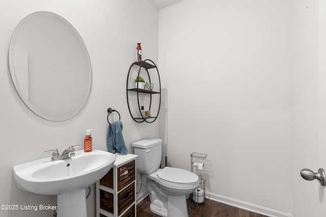 bathroom featuring hardwood / wood-style flooring, toilet, and sink