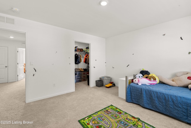 carpeted bedroom featuring a spacious closet and a closet