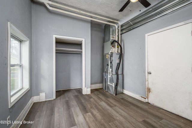 unfurnished bedroom with multiple windows, dark hardwood / wood-style floors, a textured ceiling, and ceiling fan