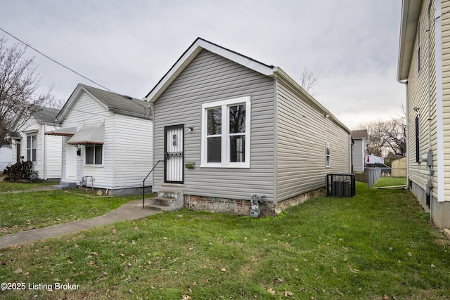 view of front of home with central AC unit and a front lawn