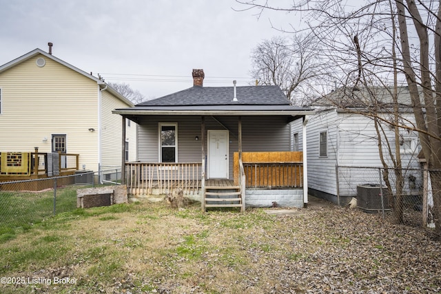 rear view of property with a porch, a yard, and central AC unit