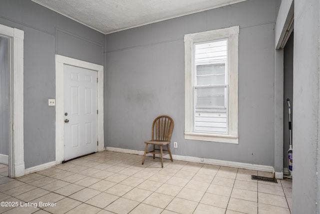 tiled entryway featuring a textured ceiling