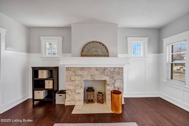 living room featuring dark hardwood / wood-style flooring, crown molding, and a fireplace