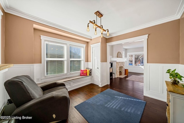 living area featuring crown molding, dark wood-type flooring, and an inviting chandelier