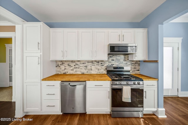 kitchen featuring butcher block countertops, white cabinetry, dark hardwood / wood-style floors, stainless steel appliances, and backsplash