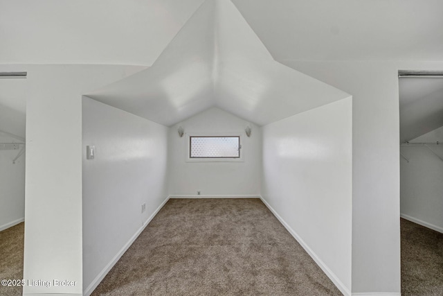 bonus room with vaulted ceiling and carpet